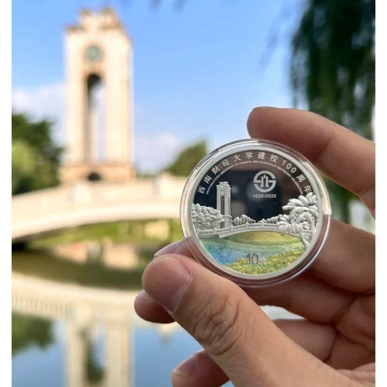 Custom commemorative coin with architectural relief and enamel scenery, held outdoors.