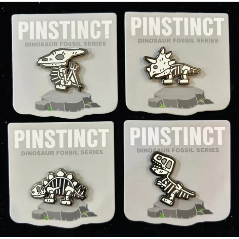 Dinosaur fossil enamel badge collection on backing cards.