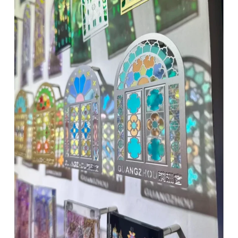 Hanging display of cut-out metal bookmarks with colorful floral window patterns.