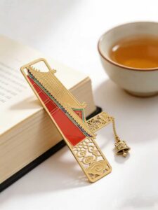 Custom gold-tone metal bookmark with enamel pagoda design, filigree cutouts, and bell charm for libraries and cultural gifts