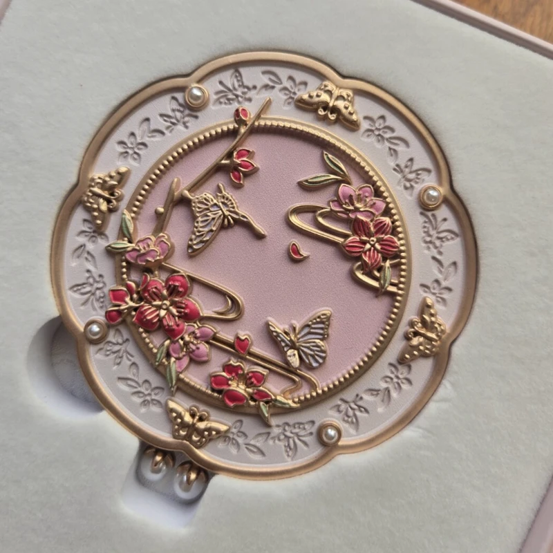 Purple compact mirror with gold-tone and red floral relief and pearl details.