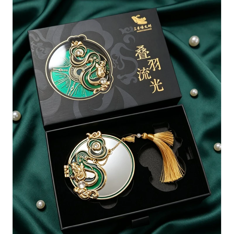 Green and gold-tone ornate folding mirror with a tassel in a black gift box.